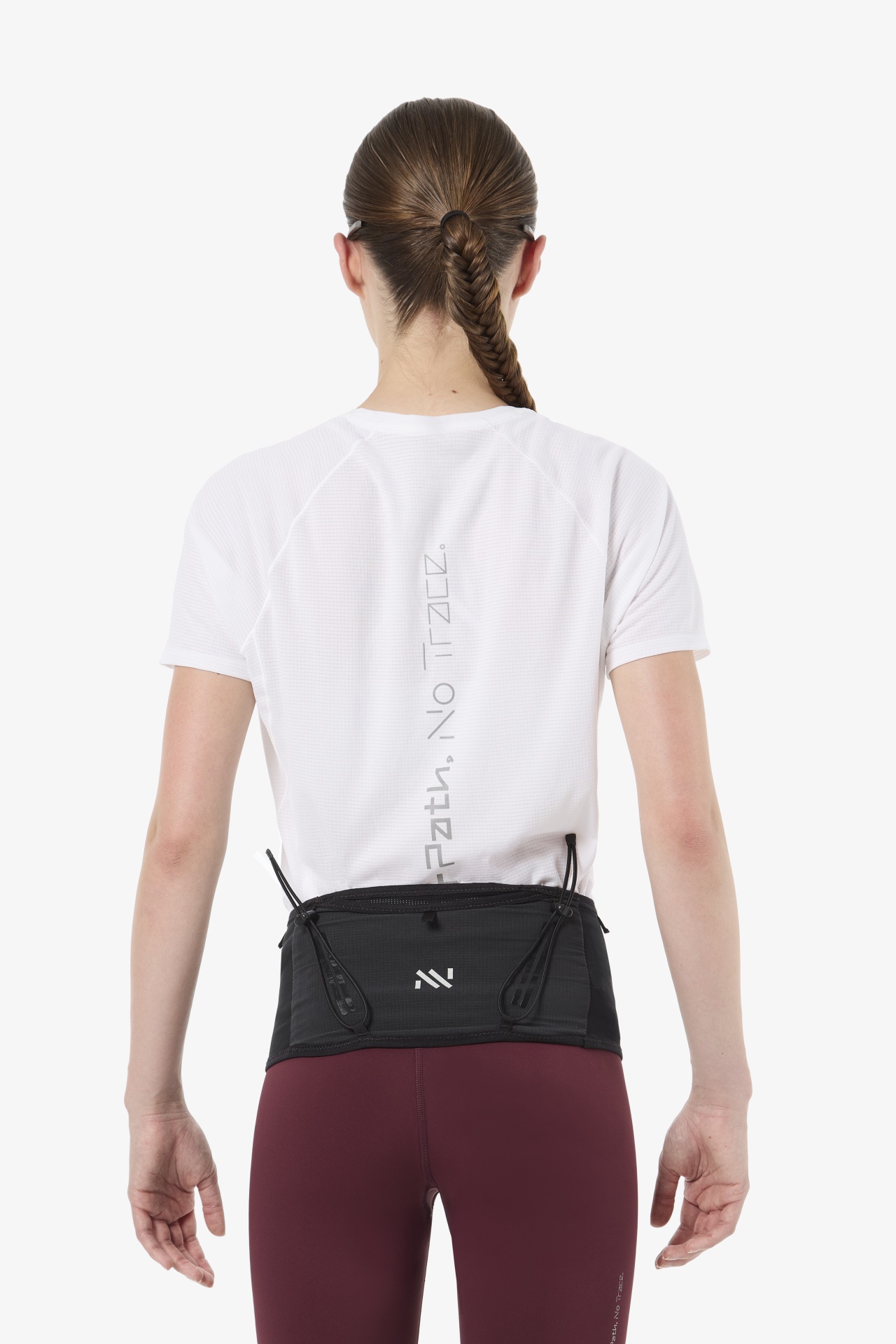 Mulher vista de costas com camiseta branca e calças vinho com faixa preta à cintura