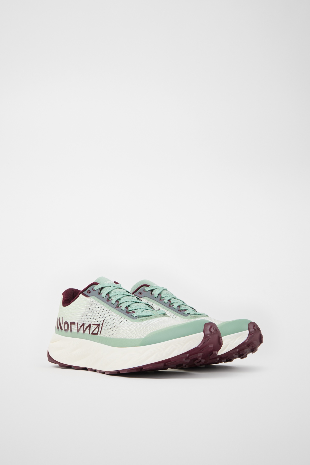 Par de sapatilhas desportivas verdes e bordo em fundo branco