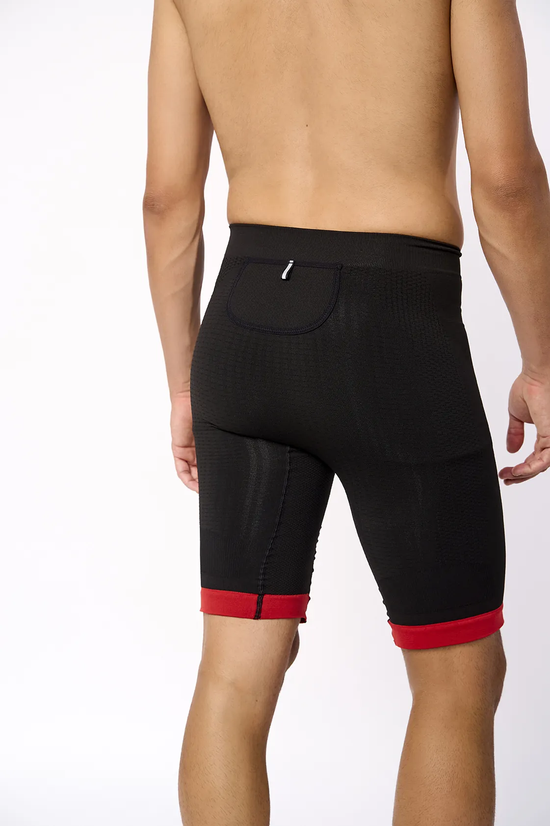 Calções pretos com barra vermelha e bolso traseiro, modelo de costas, fundo branco