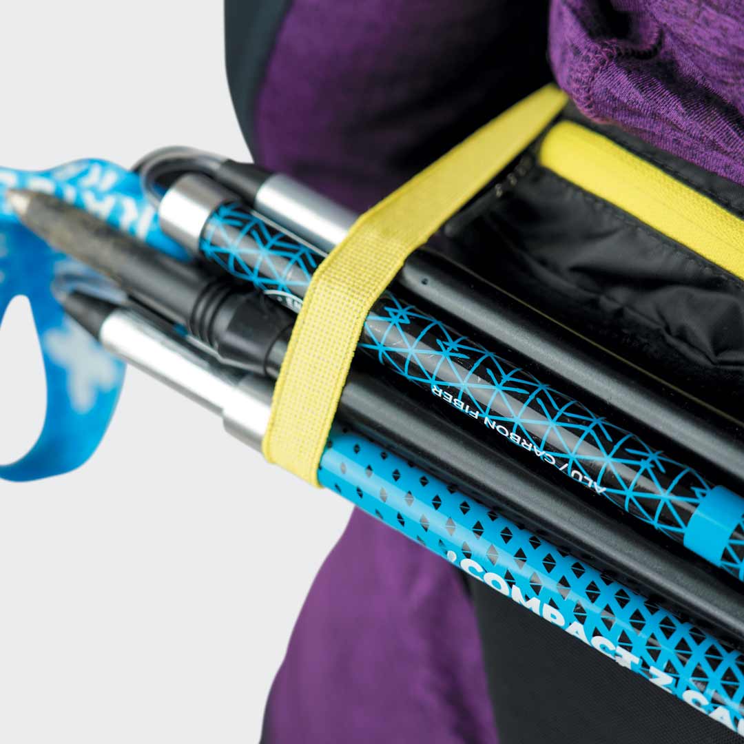 Bastões de caminhada em carbono azul e preto com fita amarela e tecido roxo ao fundo