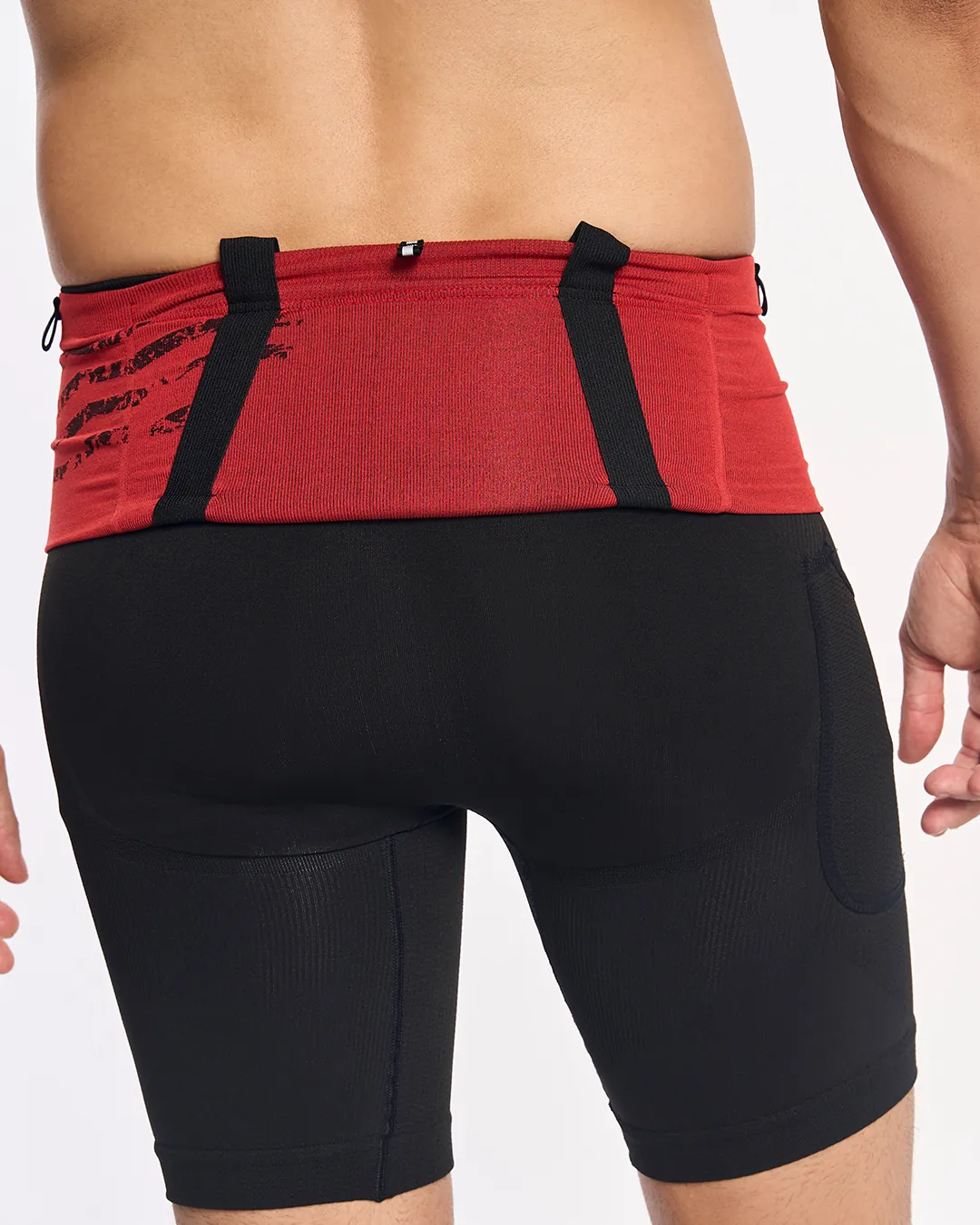 Calça desportiva preta justa com cinto vermelho na cintura vista de costas