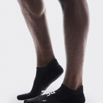 Meias desportivas pretas com padrão branco usadas nos pés