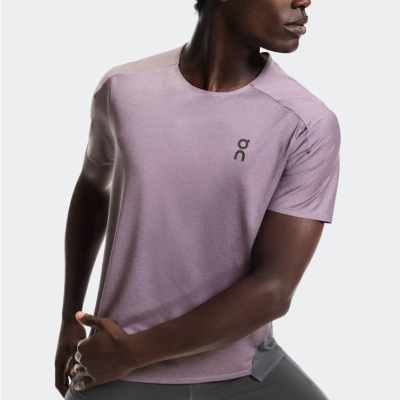 Homem a usar t-shirt rosa claro com logotipo ON e calções cinza escuro em pose de alongamento