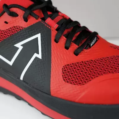 Tênis desportivo vermelho e preto com seta branca na lateral