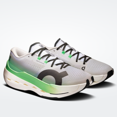 Sapatilhas desportivas brancas com verde e preto em fundo cinzento claro