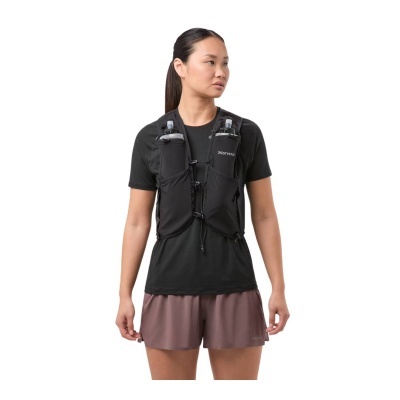 Mulher com colete de hidratação preto, t-shirt preta e calções castanhos