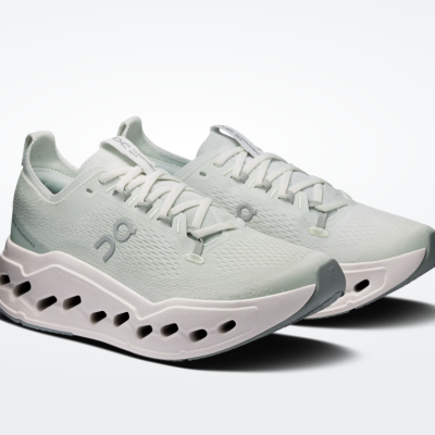 Sapatilhas desportivas brancas com detalhes cinza e sola branca com cavidades.