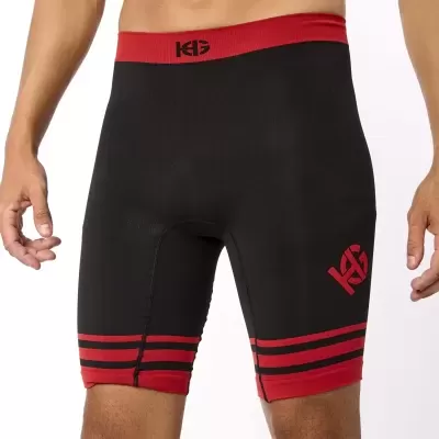 Calções de compressão pretos com faixas vermelhas e logótipo KG vermelho.