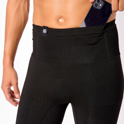 Homem a colocar telemóvel em calções pretos justos com bolso lateral