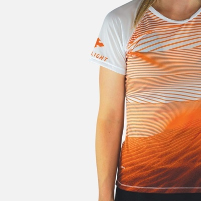 T-shirt feminina branca e laranja com padrão de linhas e textura de areia.