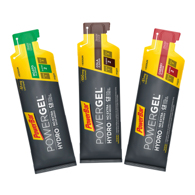 Três sachês PowerBar Powergel Hydro em cores verde, castanho e vermelho com texto motivacional.