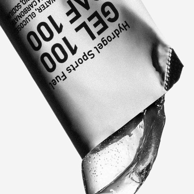 Tubo branco de gel transparente com texto preto 'GEL 100 CAFE 100' e 'Hydrogel Sports Fuel'