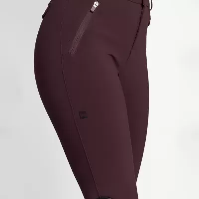 Calças justas bordeaux com fecho e bolsos com zíper, calçado preto com detalhes vermelhos