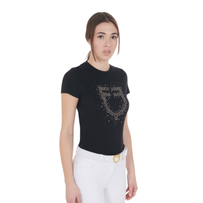 T-shirt preta com padrão brilhante dourado no peito e calças brancas com cinto branco.