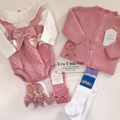 Conjunto de roupa bebé rosa e branco com acessórios e etiquetas