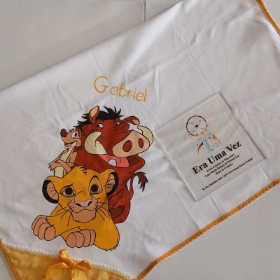 Manta branca com borda laranja, personagens do Rei Leão e nome Gabriel