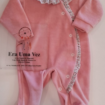 Babygrow rosa de veludo com folhos florais e botões de pressão.