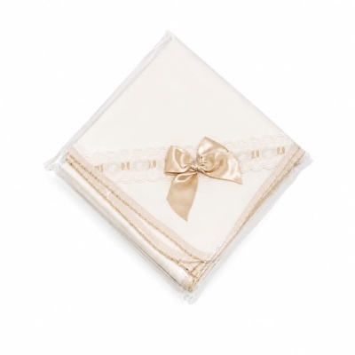 Guardanapo branco com renda e laço dourado embalado em plástico