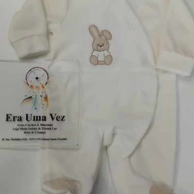 Macacão branco de bebé com coelho bordado castanho e reforços bege nas solas.