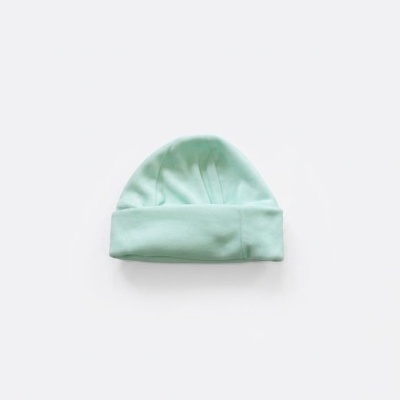 Gorro verde menta em tecido de algodão com dobra, sobre fundo branco.