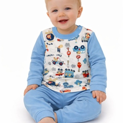 Bebé sorridente sentado com pijama azul claro e estampado de veículos
