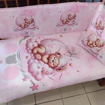 Cama ou sofá infantil rosa com ursinhos a dormir em nuvens e almofadas decoradas.
