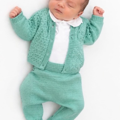 Bebé dormindo com roupa de malha verde-água e camisa branca