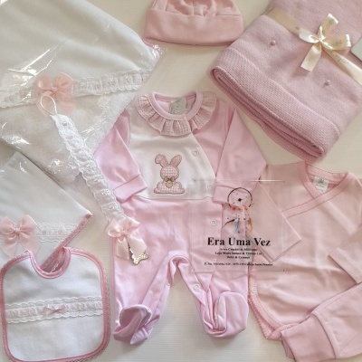 Conjunto de roupa e acessórios de bebé cor-de-rosa em fundo branco
