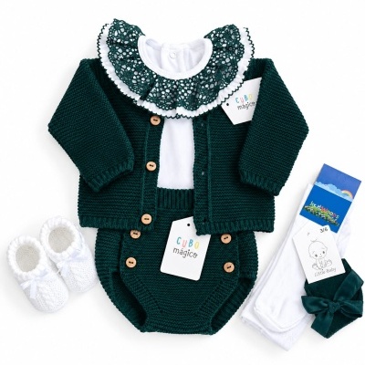 Conjunto de roupa de bebé verde escuro e branco com detalhes em lã e renda.