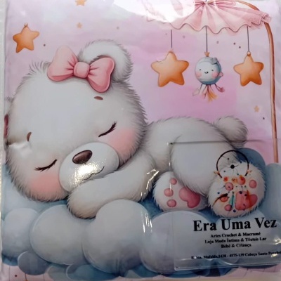 Roupa de cama infantil com estampa de urso a dormir, estrelas e móbile, embalada em plástico transparente.