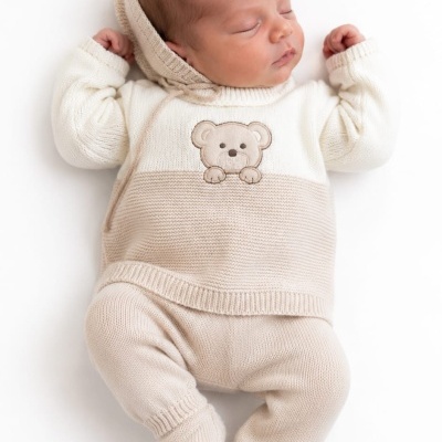 Bebé dormindo com roupa de malha bege e branca com ursinho bordado
