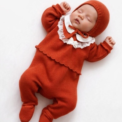 Bebe vestido com roupa de malha vermelha a dormir