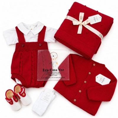 Conjunto de roupa de bebé vermelho e branco com manta e sapatinhos.