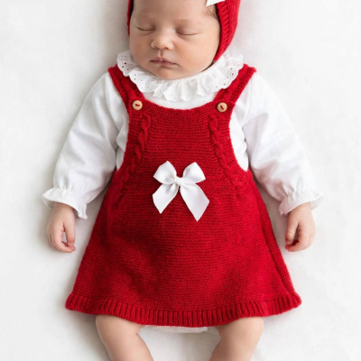 Bebé a dormir com vestido vermelho e gorro com laços brancos
