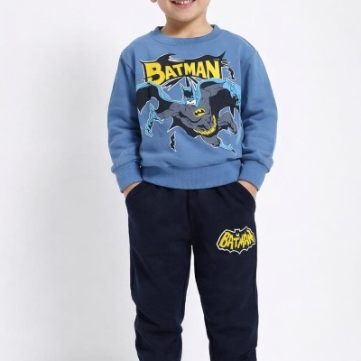 Menino com camisola azul do Batman e calças escuras com logótipo do Batman