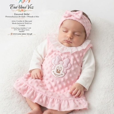 Bebé a dormir com vestido rosa e faixa de cabeça com laço rosa