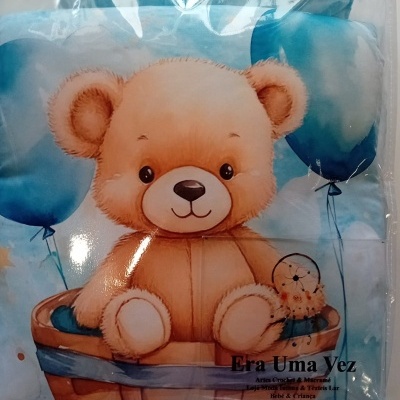 Capa de almofada azul com estampa de urso castanho em cesto e balões azuis embalada