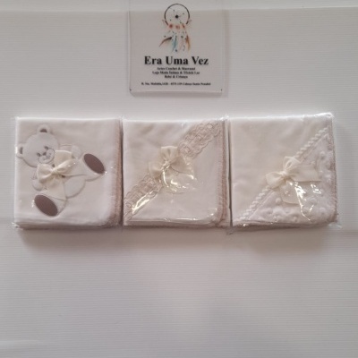 Conjunto de três mantas brancas para bebé com detalhes em renda e ursinho, embaladas em plástico