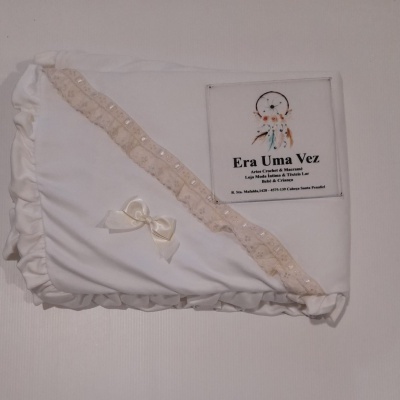 Manta branca com babados e laço, com cartão com texto da marca Era Uma Vez.