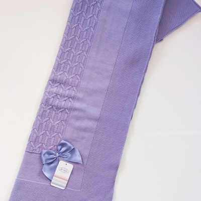 Manta de lã lilás com padrão trançado, bordas caneladas e laço de cetim lilás com etiqueta KIDS.