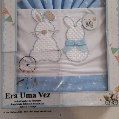 Conjunto têxtil de bebé azul e branco com bordado de coelhos e decoração de luas e estrelas
