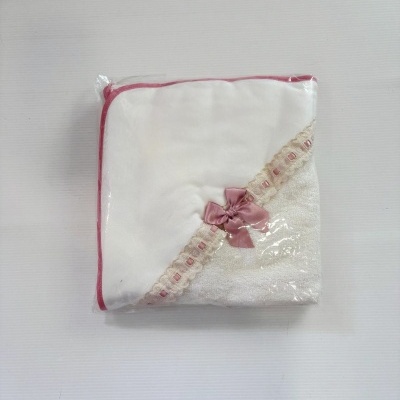 Toalha branca com borda rosa e laço cor-de-rosa embalada em plástico