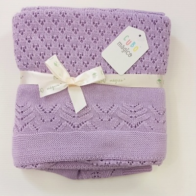 Manta lilás de malha com padrão rendado e etiqueta com texto CUBO mágico