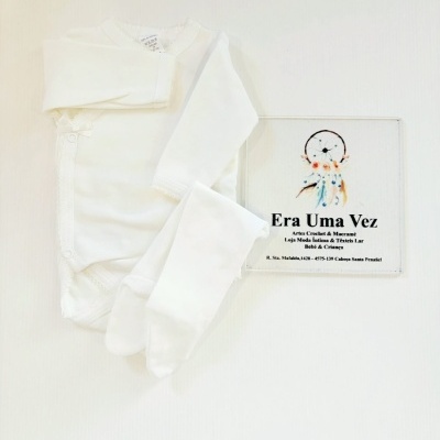 Conjunto de roupa de bebé branco com body de manga comprida e peúgas junto a cartão com texto e filtro dos sonhos