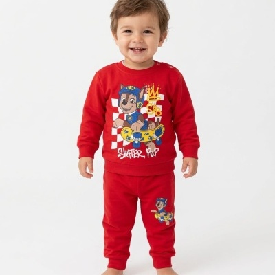 Criança sorridente a usar roupa de criança vermelha com cão animado a andar de skate.