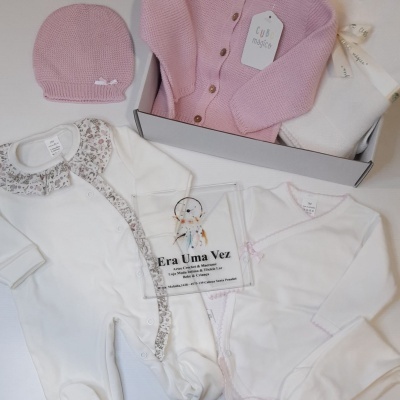 Conjunto de roupa para bebé com peças em algodão e malha em tons rosa e branco em caixa cinzenta