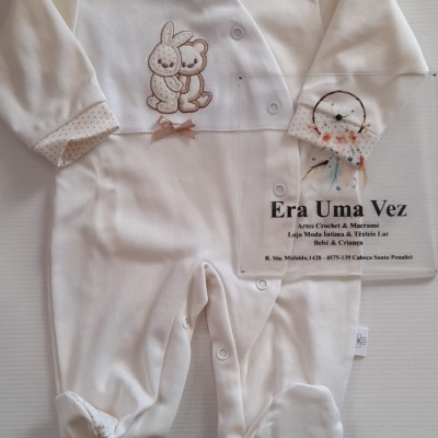 Pijama bebé branco e creme com bordado de ursinho e coelho, botões à frente e padrão de pontos nas mangas e pés.