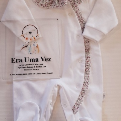 Pijama branco de bebé com gola e folhos florais e embalagem transparente com texto