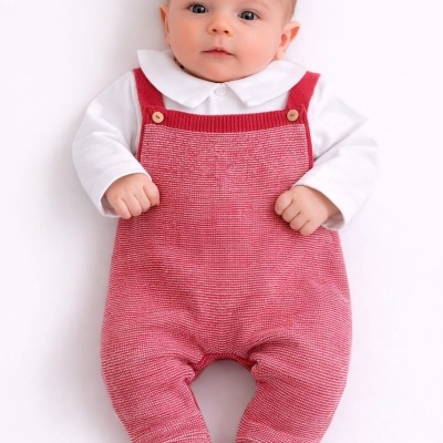 Bebê vestindo camisa branca e macacão vermelho de malha em fundo branco