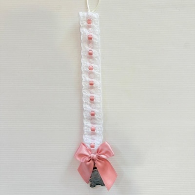 Prendedor de chupeta branco com laço rosa e pendente metálico